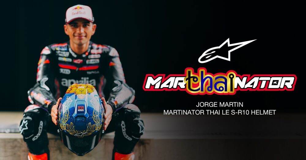 Jorge Martín con mono Aprilia sosteniendo un casco azul y dorado. Incluye el texto MARTHAINATOR y Alpinestars.